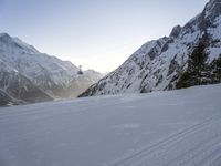 a skier goes down an alpine mountain slope and looks back toward the gondola lift