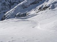 a snow boarder is riding down the snowy slopes of a mountain side mountain in winter