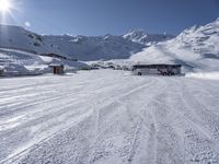 a bus sits on the snow, waiting at the mountainside to board you up