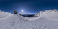 a ski jump that shows off as seen through a fisheye lens with the sun in the background