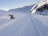 a man snowboarding in the deep white snow at a ski resort near an arctic lodge