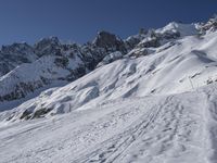 a skier is leaving the trail as it makes its way uphill in the snow