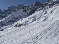 a skier is leaving the trail as it makes its way uphill in the snow