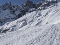 a skier is leaving the trail as it makes its way uphill in the snow