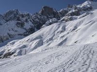 a skier is leaving the trail as it makes its way uphill in the snow