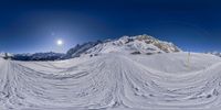 a person riding skis on a snowy slope with the sun shining in the background