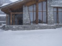 a building that is on some snowy ground under some snow flakes is behind it