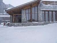 a building that is on some snowy ground under some snow flakes is behind it