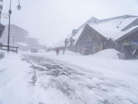 the snow is falling down the road on the snowy day, and it looks cold