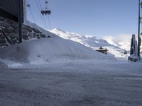 a car is parked on the side of the road covered in snow with the lift in the background