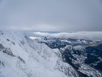 a man walking on top of snow covered mountain peaks in front of clouds with the word, free