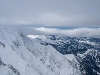 a man walking on top of snow covered mountain peaks in front of clouds with the word, free