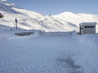 this is a view of a snowy mountainside from the top of a hill, looking down at a small store