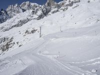 skiers make their way down a slope in the snow near some mountains on the side