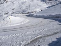 two people on skis going down a snowy slope near mountains or houses in the distance