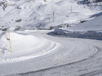 two people on skis going down a snowy slope near mountains or houses in the distance