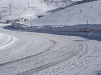 two people on skis going down a snowy slope near mountains or houses in the distance