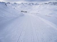 snow covered slope in the middle of a ski area as people ski on it near ski lift