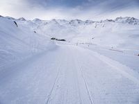 snow covered slope in the middle of a ski area as people ski on it near ski lift