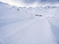 snow covered slope in the middle of a ski area as people ski on it near ski lift