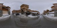 a group of buildings with snow covering the roof and street in front of them and below