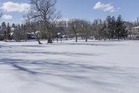 some houses and a field covered with snow in the winter snow covered area of a park