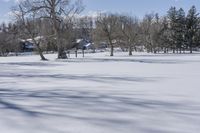 some houses and a field covered with snow in the winter snow covered area of a park