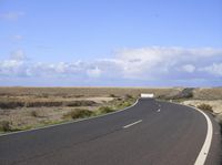 an empty road with an arrow sign pointing left and right and to the right, on the side of the road