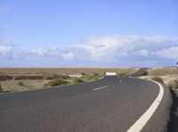 an empty road with an arrow sign pointing left and right and to the right, on the side of the road