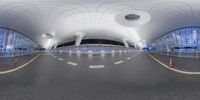 a panoramic view of an airport entrance with lots of arches and lights on