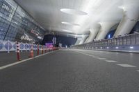 a view of an airport at night with multiple lights on and empty roads in between