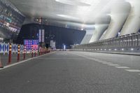 a view of an airport at night with multiple lights on and empty roads in between