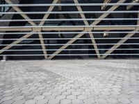 a building with some metal bars and bricks flooring on the outside of it in sunlight