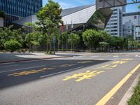 the sidewalk is wide and empty in a city setting with a sky background, there are trees, buildings, a traffic light and a blue sky