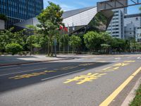 the sidewalk is wide and empty in a city setting with a sky background, there are trees, buildings, a traffic light and a blue sky