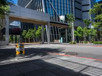 there is a yellow and black fire hydrant on the street in front of tall buildings