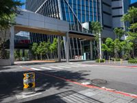 there is a yellow and black fire hydrant on the street in front of tall buildings