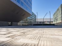 an empty brick plaza surrounded by tall buildings in the city of barcelona, spain with traffic on the roads