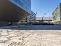 an empty brick plaza surrounded by tall buildings in the city of barcelona, spain with traffic on the roads