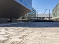 an empty brick plaza surrounded by tall buildings in the city of barcelona, spain with traffic on the roads