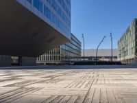 an empty brick plaza surrounded by tall buildings in the city of barcelona, spain with traffic on the roads