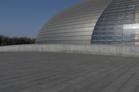 a person on a skateboard in front of a big building with a curved roof