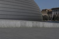 a person on a skateboard in front of a big building with a curved roof