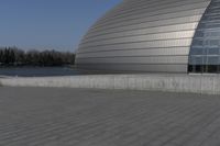 a person on a skateboard in front of a big building with a curved roof