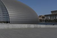 a person on a skateboard in front of a big building with a curved roof