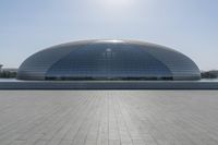 a person on a skateboard in front of a big building with a curved roof