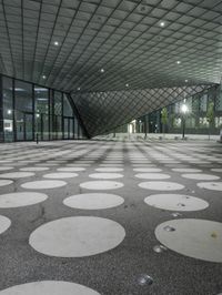 the floor has large circular tiles on it as well as a roof above a building