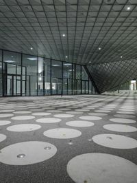 the floor has large circular tiles on it as well as a roof above a building