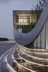 stairs and lighting show a modern architecture building with a large circular design on top of the stairway