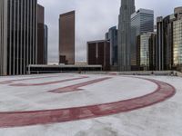 a very pretty round shaped concrete field next to the buildings in a city park with no snow